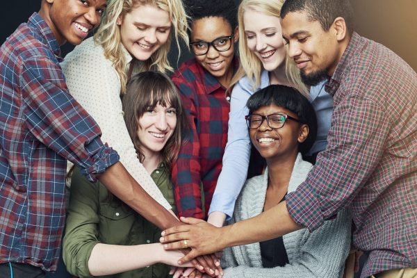 Heres to positive partnerships. Shot of a group of people putting their hands together